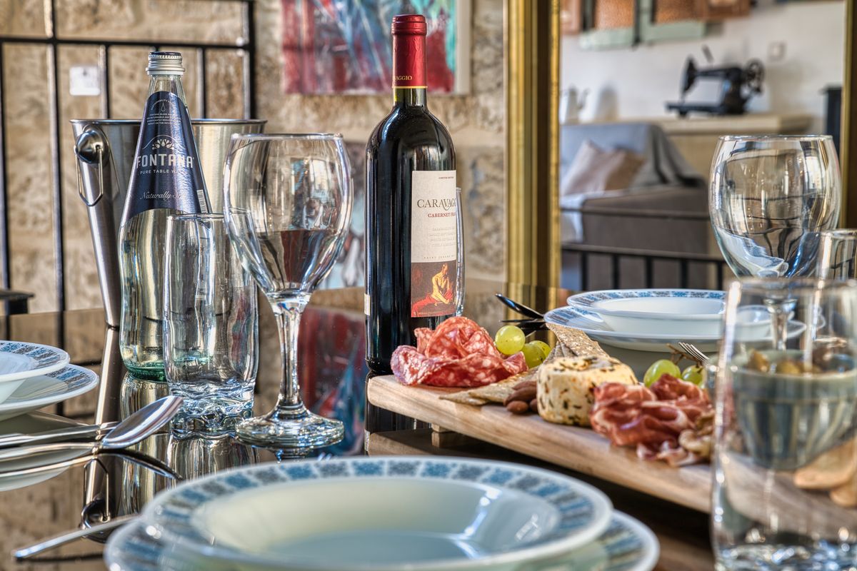 Dining table laid with plates, wine and a platter of local food